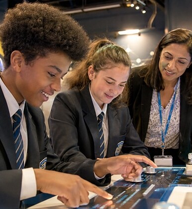 Students and teacher engaging with an interactive science exhibit at a museum